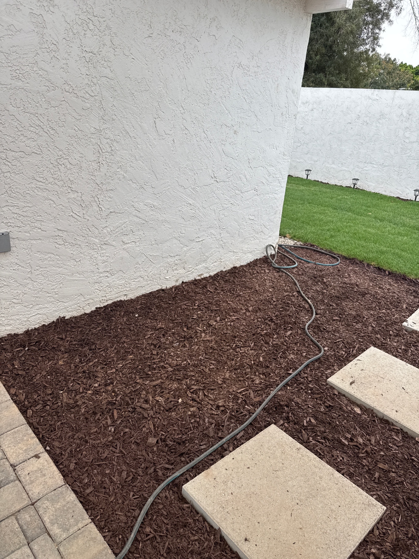 New landscape bed with mulch, stepping stones, and lawn edge at 3037 E Clarendon Ave